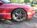 1993 Ford Probe - Close-up of the front wheel and fender of a red 1993 Ford Probe GT.