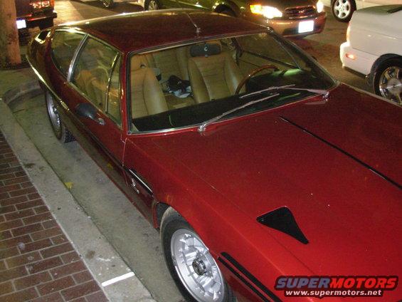 Red coupe with tan interior and distinctive side vents