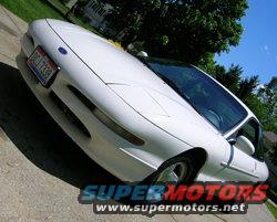 White 1997 Ford Probe with a license plate that reads 'CJ 7338'. The car is angled from the front-right