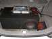 1992 Ford Crown Victoria - The trunk of a car contains a subwoofer, amplifier, and wiring, suggesting aftermarket audio installation.