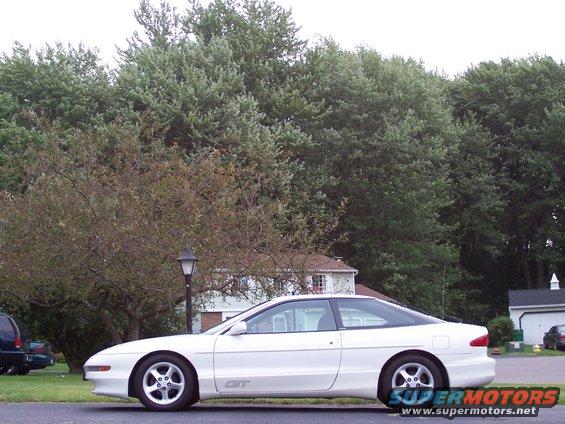 White 1993 Ford Probe GT parked on a street with trees and houses in the background