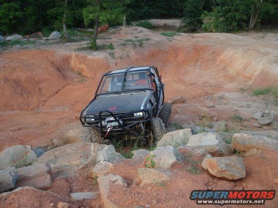 Off-road vehicle with roll cage navigating rocky terrain