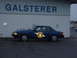 1978 Ford Mustang II - A blue Michigan State Police car is parked in front of a building with 'GALSTERER' signage.