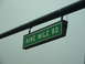 1978 Ford Mustang II - A street sign for Nine Mile Road hangs from a dark overhead structure against a cloudy sky.