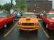 1978 Ford Mustang II - A row of classic cars, including an orange coupe with a prominent hood scoop, are parked at an outdoor event.