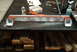 1983 Ford Bronco - A metal crossmember part is shown with red and white primer, along with a can of spray paint and a box of welding wire.