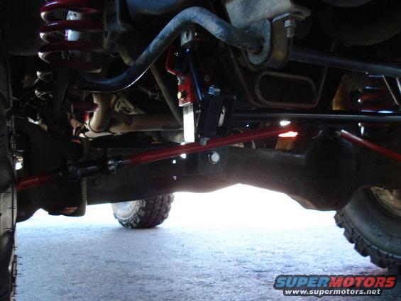 Undercarriage of a vehicle with red suspension components and a Supermotors.net watermark