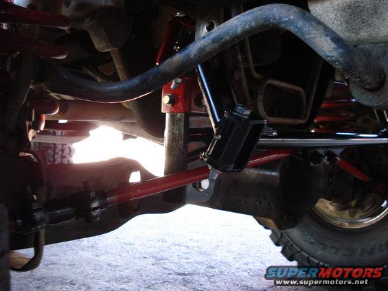 Close-up of red and black suspension parts on a vehicle's undercarriage