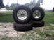 1996 Ford Bronco - Set of four off-road tires with chrome rims are displayed outdoors on a grassy area.