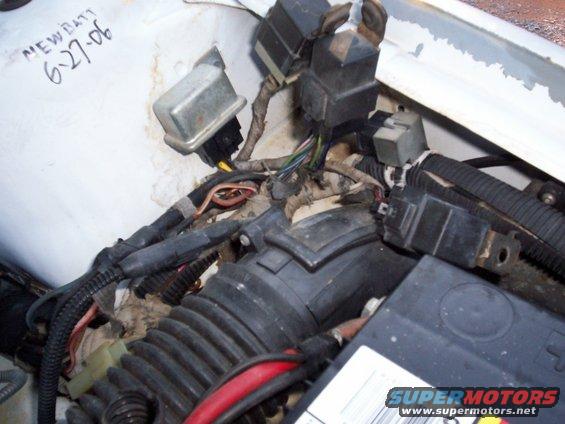 Engine bay wiring harness, relays, and air intake tube. Text on white surface reads 'NEW BATT 6-27-06'