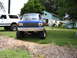1989 Ford Bronco - A lifted blue 1989 Ford Bronco is parked in a yard next to a white SUV.