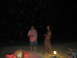 1989 Ford Bronco - Several individuals are visible on a beach at night, with a small campfire providing illumination.