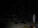1989 Ford Bronco - A person stands near a large truck parked on a sandy area after dark.