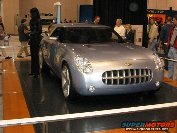 Silver concept car with a prominent chrome grille and round headlights on display