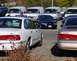 1995 Ford Crown Victoria - A row of vehicles including a white 1995 Ford Crown Victoria is parked in an outdoor lot.