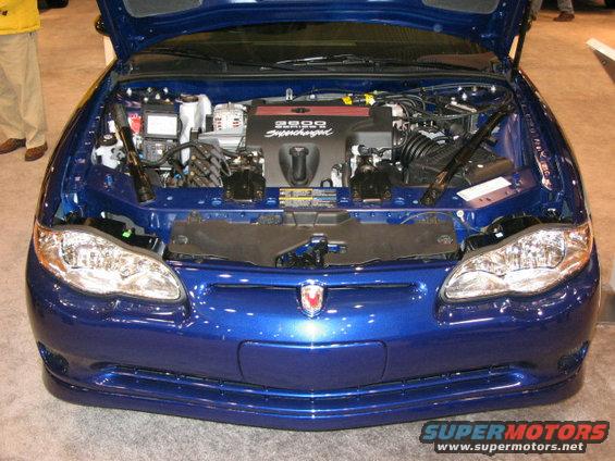 Front view of a blue car with hood open, showing the engine and "3800 Supercharged" cover