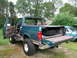 1996 Ford Bronco - This 1996 Ford Bronco is shown from the rear with its tailgate and doors open, revealing the spare tire and interior.