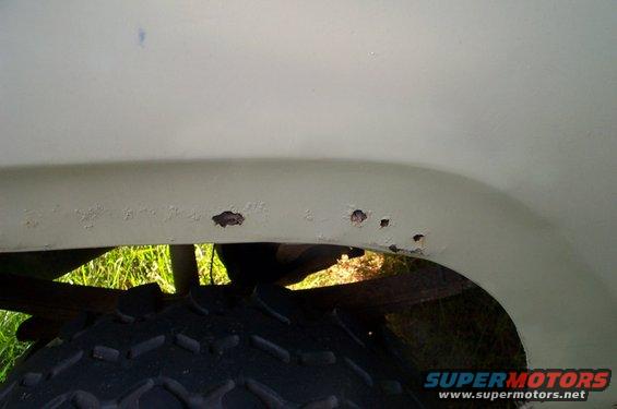 Rust spots on fender above tire