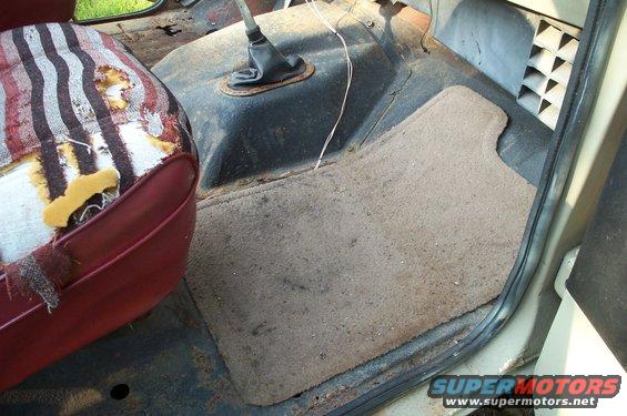 Torn striped seat and floor mat inside a vehicle