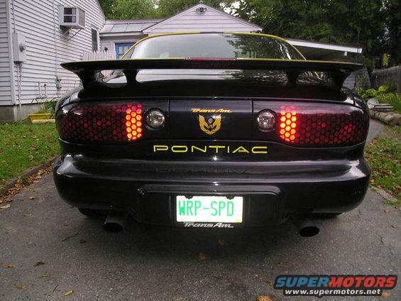Rear of a black 1994 Pontiac Trans Am with a spoiler and honeycomb taillights