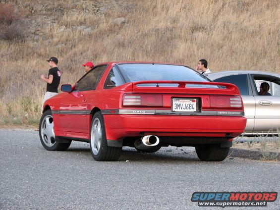 Red Toyota Supra Turbo coupe parked next to a silver sedan. California license plate 3MVJ684