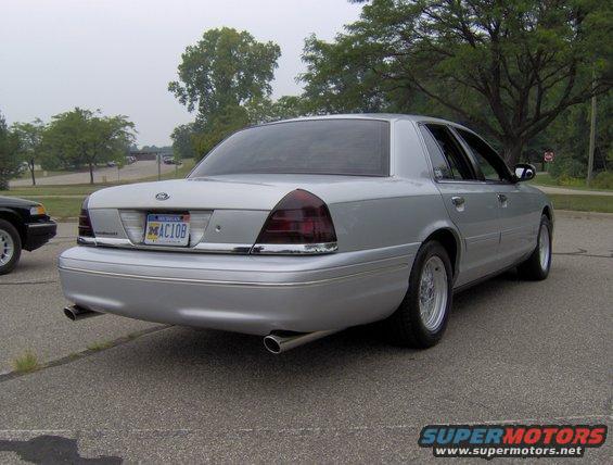 Silver 2002 Ford Crown Victoria sedan, rear view, with dual exhaust pipes and aftermarket wheels