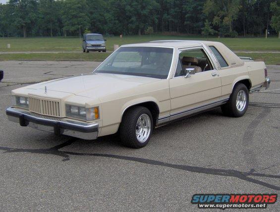 Tan Ford sedan with chrome wheels and vinyl roof