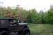 1979 Ford Bronco - A driver navigates a muddy trail in a Jeep CJ-5, surrounded by autumn foliage.