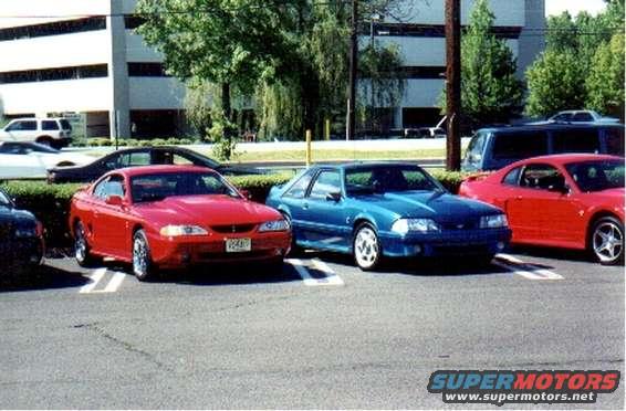 Blue 1987 Ford Mustang Fox Body parked in a lot next to a red car