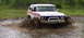 1979 Ford Bronco - This Ford Bronco navigates a muddy terrain, kicking up water and dirt.
