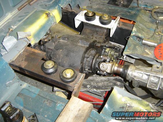 Transmission and driveshaft components installed in a vehicle chassis, with mounting hardware visible