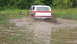1979 Ford Bronco - A red and white Ford Bronco navigates a muddy obstacle course.