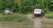 1979 Ford Bronco - A 1979 Ford Bronco kicks up mud as it navigates off-road, with another truck visible in the background.