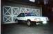 1989 Ford Mustang - This 1989 Ford Mustang GT is captured in a three-quarter front view, parked outside a garage with an American flag on its antenna.