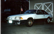 1989 Ford Mustang - This 1989 Ford Mustang GT coupe is shown in a three-quarter front view, parked outside a garage.