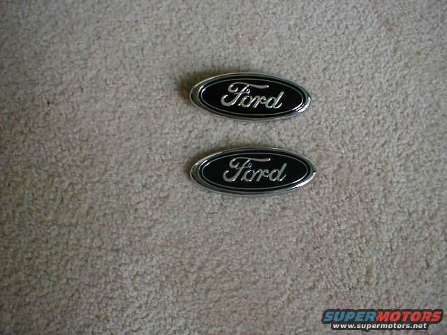 Two Ford oval emblems on carpet