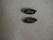2002 Ford Crown Victoria - Two Ford oval emblems are shown on a carpeted surface.