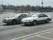 1989 Ford Mustang - Two Ford Mustangs, one from 1989 and a newer model, are parked in an outdoor lot.