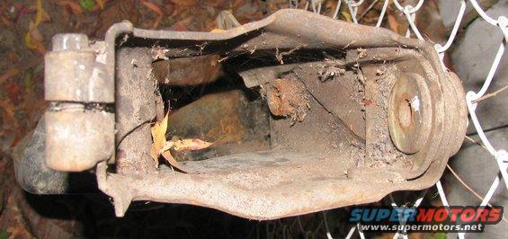 rusted metal suspension component with bolts and cobwebs
