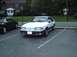 1989 Ford Mustang - A white 1989 Ford Mustang coupe is parked in a lot next to a black car.