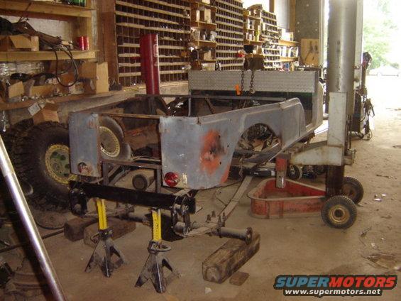 Jeep CJ-6 body on jack stands in a workshop