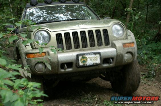 2006 Jeep Liberty driving on a dirt trail with trees around it