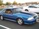1989 Ford Mustang - A blue 1989 Ford Mustang coupe is seen from the front-three-quarter view in a parking lot.