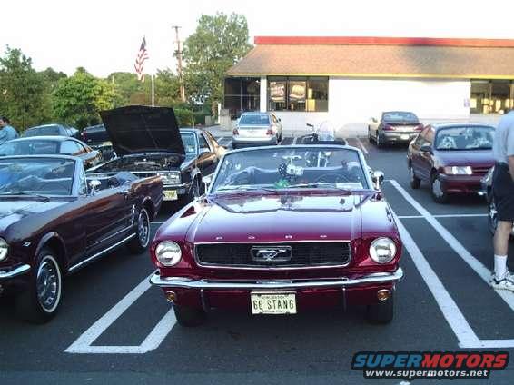 Red 1966 Mustang convertible front view with "66 STANG" license plate