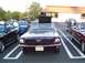 1989 Ford Mustang - Two classic Ford Mustangs and a motorcycle are parked in a lot.