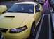 1989 Ford Mustang - This yellow Ford Mustang is parked in a lot with dice hanging from the rearview mirror.