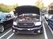 1989 Ford Mustang - A dark blue Ford F-150 SVT Lightning is displayed with its hood open, the engine and a trophy.