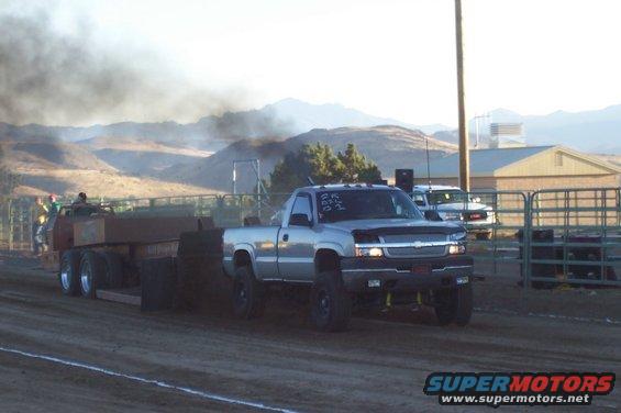 Silver pickup truck with "ER ABC 01" on windshield, pulling a trailer