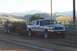1994 Ford F-150 - A Ford F-250 Super Duty truck is seen pulling a trailer in a rural setting with mountains in the background.