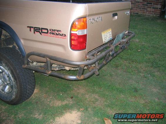Tan Toyota Tacoma pickup truck rear with TRD Off Road decal and custom bumper